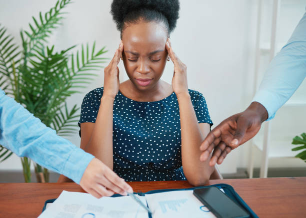 istock Young Black woman stressed at work due to paperwork and reports 1473709597