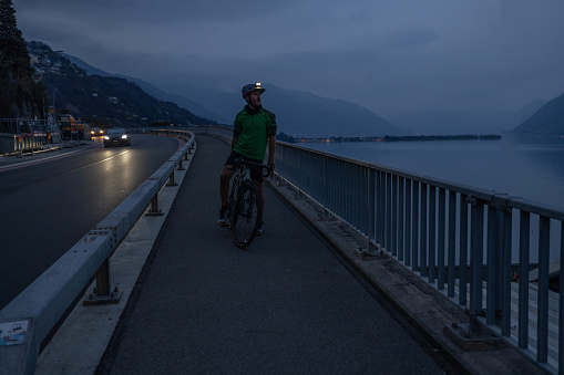 Outdoor fitness at night. Man cyclist training at night