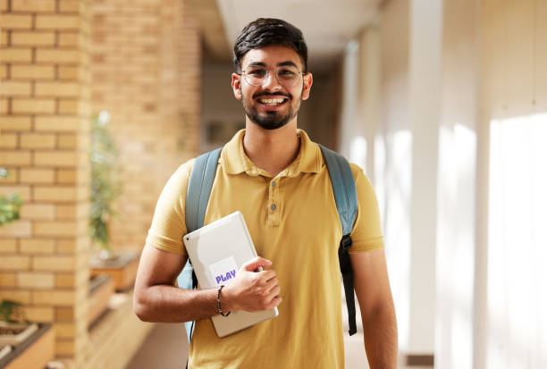 ritratto del viso, studente e uomo all'università pronto per l'apprendimento del ritorno a scuola, obiettivi o obiettivi. borsa di studio, istruzione e felice, fiducioso e orgoglioso maschio dall'india in possesso di tablet per studiare. - college life immagine foto e immagini stock