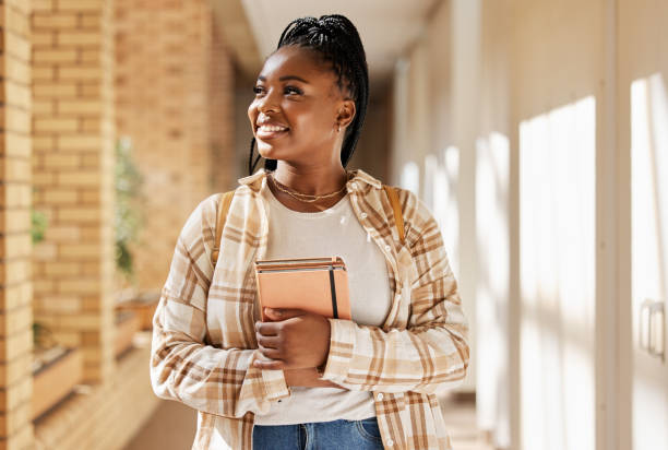 Black woman, college student and thinking about future with books while walking at campus or university. Young gen z female happy about education, learning and choice to study at school building mujer negra, estudiante universitaria y pensando en el futuro con libros mientras camina en el campus o la universidad. joven generación z femenina feliz con la educación, el aprendizaje y la elección de estudiar en el edificio de la escuela