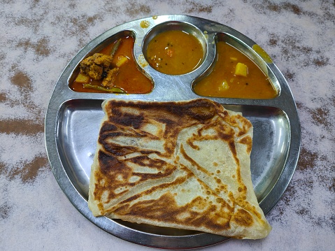 Malaysian favourite - Square shaped roti canai (paratha) with dhal and curry chicken dipping sauce