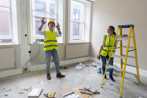 A shot of two building contractors standing and discussing interior ideas for a project they are working on.