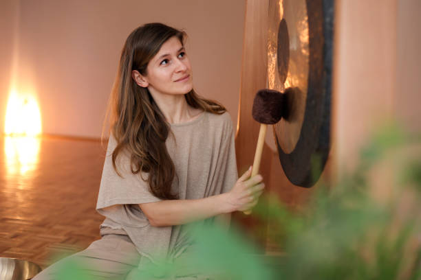 istock Young woman playing a gong 1473712999