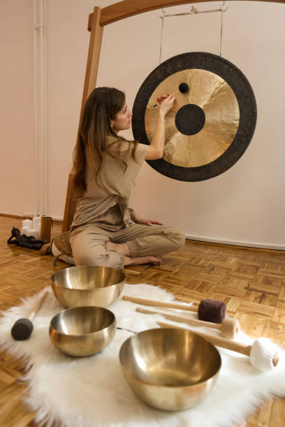 istock Young woman playing a gong during a sound massage 1473713571
