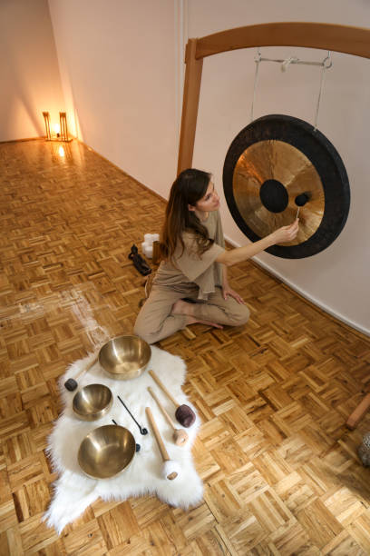 istock Young woman playing a gong during a sound massage 1473713621