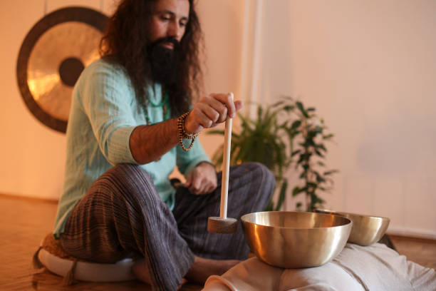 istock Man playing a rin gong during a sound therapy 1473714384