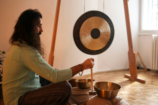 istock Man playing a rin gong during a sound therapy 1473714406