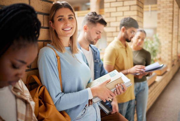 università, hall e ritratto di donne e studenti in fila insieme ai libri della business school. amici, istruzione e futuro, ragazza dagli stati uniti nel gruppo di studio nel campus nel corridoio per l'esame - lecture hall university student seminar foto e immagini stock