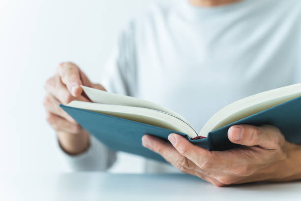 istock Adult writing and reading book. Student studying or learning with textbook at home. Success idea concept of education knowledge development and cognition learning .Business and education concept 1473718749