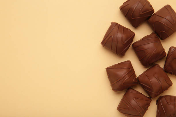 istock Chocolate candies on beige background. Top view 1473718999