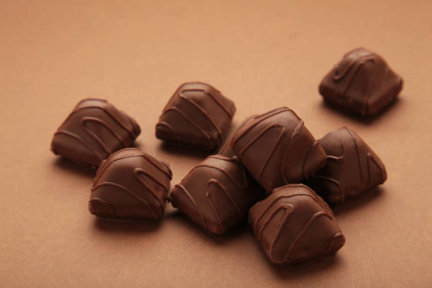 istock Chocolate candies on brown background. Top view 1473719010