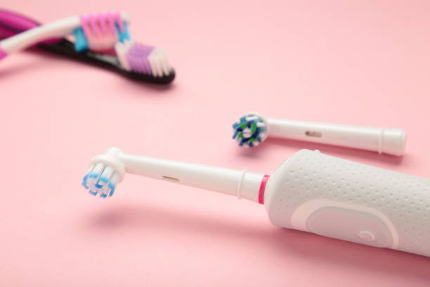 istock Electric and manual toothbrush on pink background. Vertical photo 1473719087