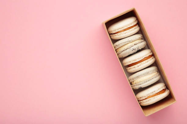 istock Pastel macaroons in box on pink background. Space for text 1473719883