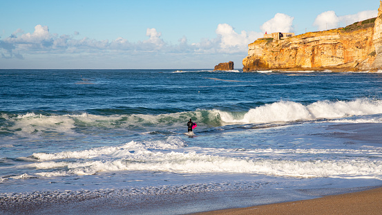 Bodysurfer on Nazare Beach at sunny day. Portugal