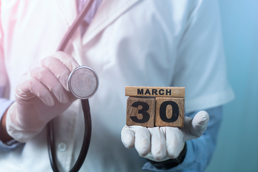 Doctor's Day image, Doctor with stethoscope and wooden Calendar date, Medical concept image