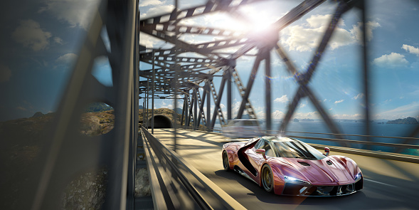 A modern generic red sports car driving at speed over a steel construction bridge over a span of sea. The car is moving at speed on a bright day with the sun overhead with motion blur to the background. Location is fictional. Car, bridge and tunnel are CGI.