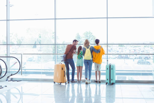 istock Family looking through airport window 1473727340