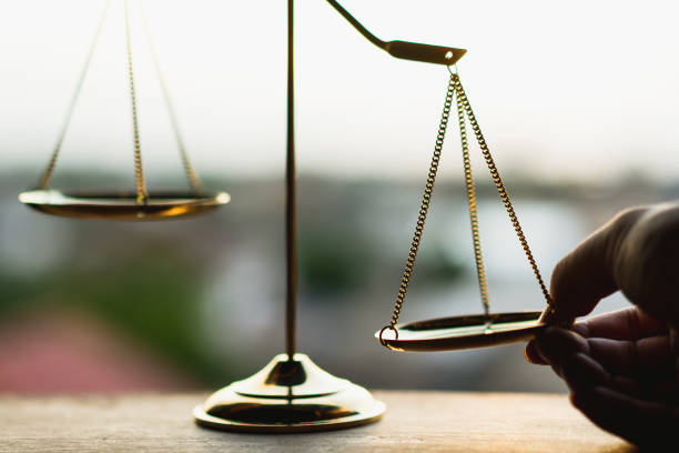 Tip the scales of justice concept as a the hand of a person illegally influencing the legal system for an unfair advantage. stock photo