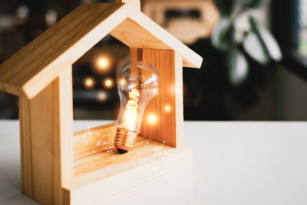 istock Light bulb with wood house on the table, a symbol for construction, Creative light bulb idea, power energy or business idea concept ecology, loan, mortgage, property or home. 1473727895