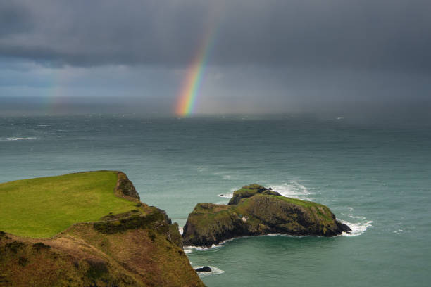 istock Rainbow and stormy sky above the sea and rugged coast 1473728973