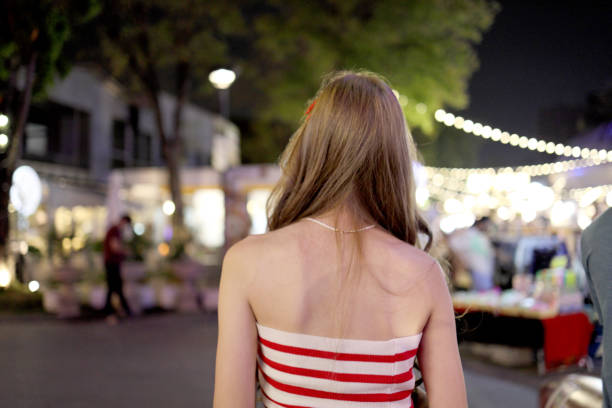 The cute Asian woman walking in the nightmarket in Thailand.