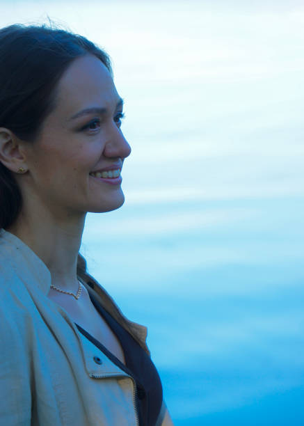 istock Smiling young woman looking away against sea 1473729663