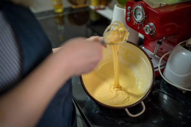 istock Young woman in a gray aprons breaks the eggs 1473730275