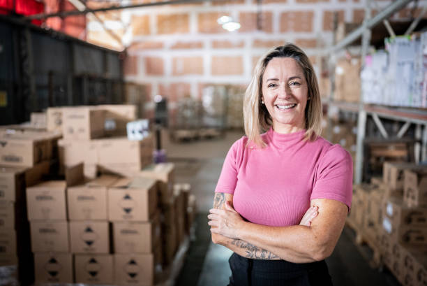 porträt einer geschäftsfrau in einem lagerhaus - manager foreman warehouse arms crossed stock-fotos und bilder
