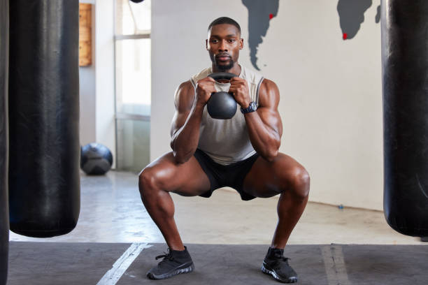 黒人男性、ケトルベルスクワット、ジム、フィットネスクラブ、スポーツトレーニングでの運動。ウェイトトレーニング、リフティングとエネルギー、ウェルネスまたは健康的なライフスタ� - men weight training african descent male ストックフォトと画像