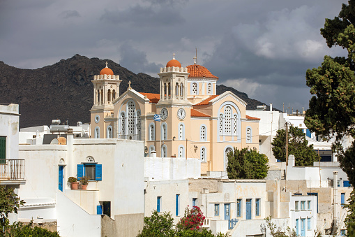 Cyclades, Greece. Tinos Greek island, Pyrgos village Agios Nikolaos church and white color buildings, cloudy sky