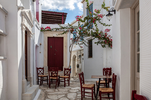 Greece. Tinos island Cyclades. Outdoors traditional cafe at Pyrgos village. Empty chairs and tables on cobblestone alley