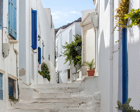 Greece. Tinos island of art, Cycladic architecture at Pyrgos village paved street, whitewashed wall, stair, sunny day.