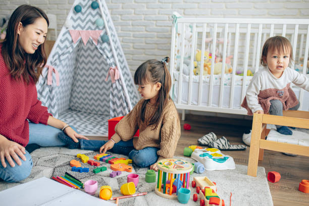 istock Mother and her two daughters playing in kids room 1473732500