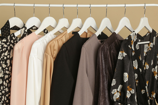 Women's Clothes. Clothes rack with stylish and elegant garments in fashion atelier. Good quality timeless fashion pieces.