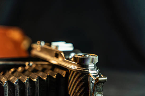 istock Antique fold photocamera on black background 1473737882