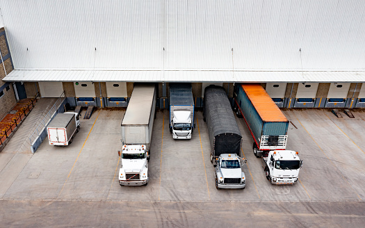 Trucks parked in a distribution warehouse ready to deliver some cargo - freight transportation concepts