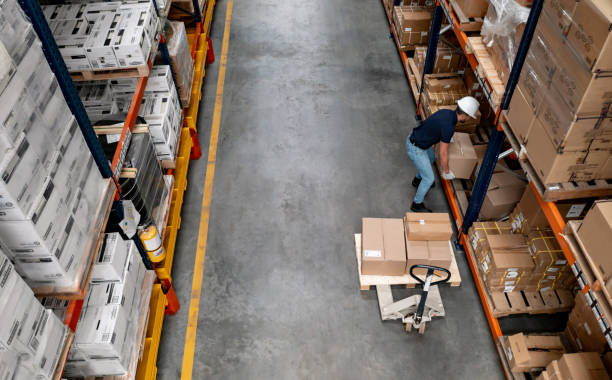 istock Man working at a distribution warehouse placing boxes on shelves 1473740813
