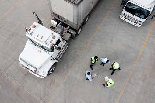 Logistics team working at a distribution warehouse loading trucks with cargo for delivery