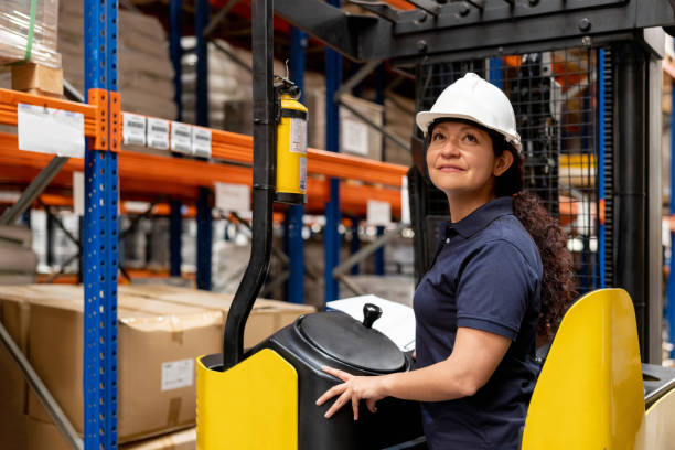 istock Happy woman working at a distribution warehouse driving a forklift 1473740874