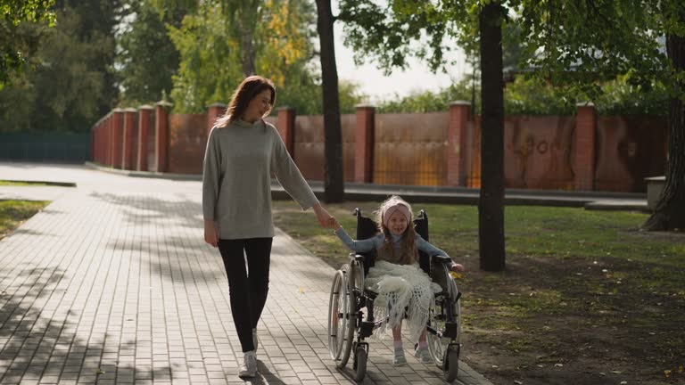 Woman walks on stone road holding hand of little daughter