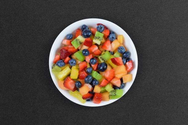 istock Bowl of colorful fresh fruit on dark background 1473744347