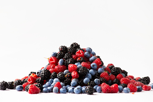 Fresh organic berries close-up isolated. Colorful composition of blueberries, raspberries, blackberries on a white background. Useful berries.