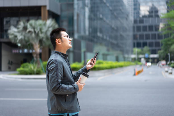istock Chinese office worker using mobile phone with coffee at outdoors 1473746313