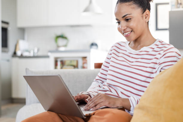 istock Young woman in casual clothes using a laptop 1473747175