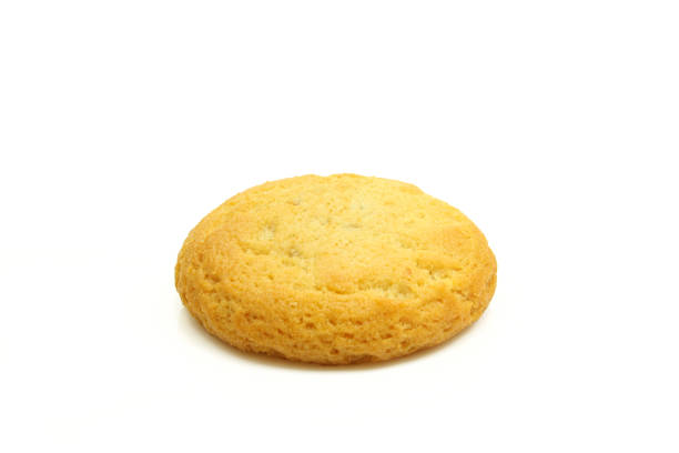 istock Single small golden treat cookie biscuit isolated on white background 1473759475