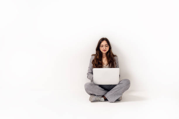 istock Young girl learning online on chat meeting using laptop. Studio shot. College female student learning remotely. 1473759733