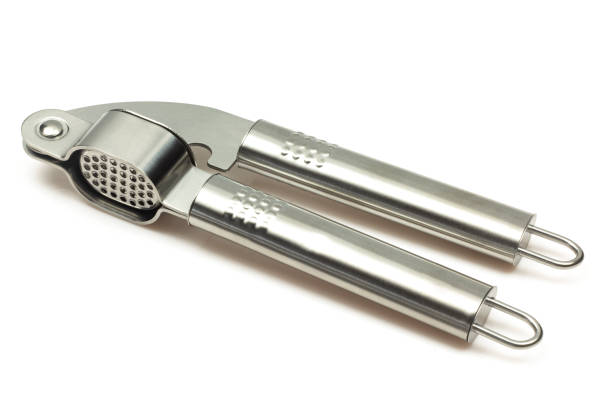 istock Metallic shiny garlic press crusher tool isolated on white background. Stainless kitchen utensil mincer 1473760961