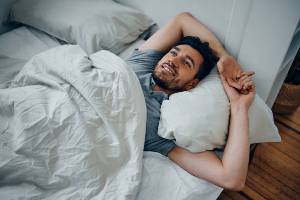 istock Happy man day dreaming while resting in his bed. 1473762958