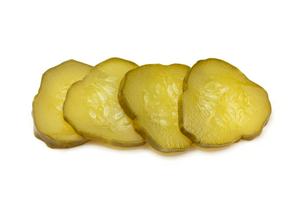 Sliced pickles isolated on white background. Cucumber vegetable pieces with seeds