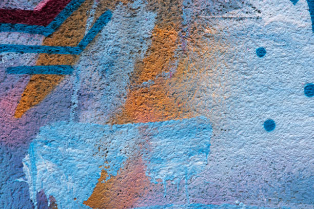 istock Messy paint strokes and smudges on an old painted wall background. Abstract wall surface with part of graffiti. Colorful drips, flows, streaks of paint and paint sprays 1473763620